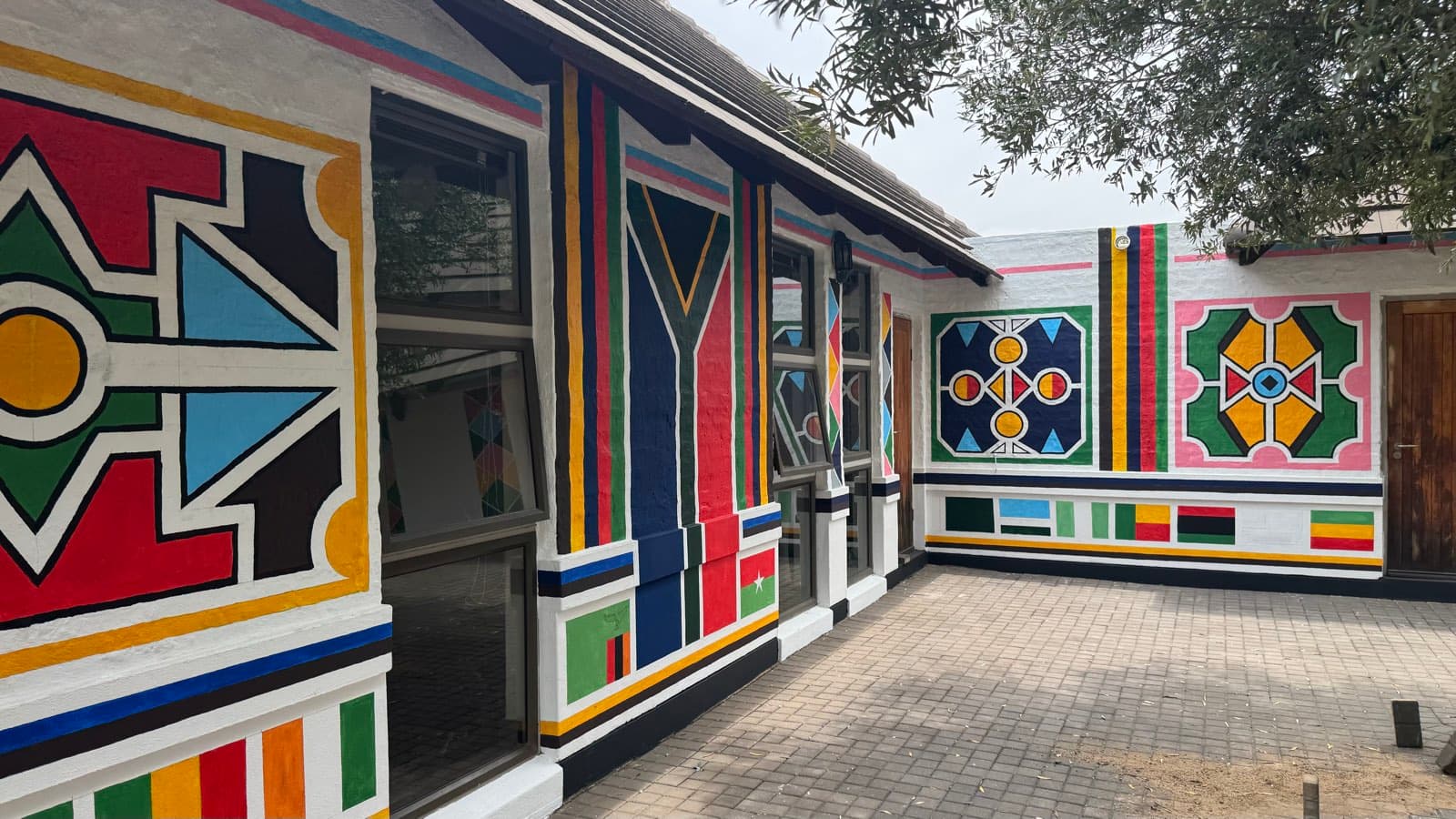 Hand-painted amaNdebele geometric murals on the homestead walls at KoMjekejeke